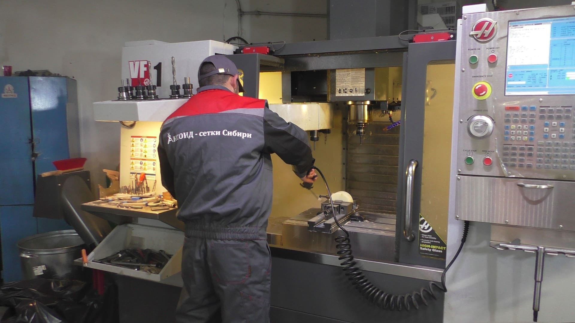 Фотография современного на 2014 год станка ЧПУ с молодым специалистом АКСОИД